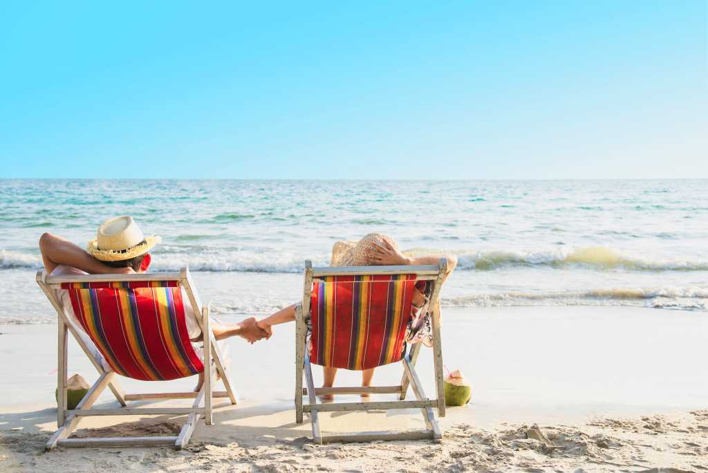 para kobieta i mężyczna leżący na leżakach plaża niebo woda 