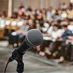 mikrofon na tle uczestników konferencji