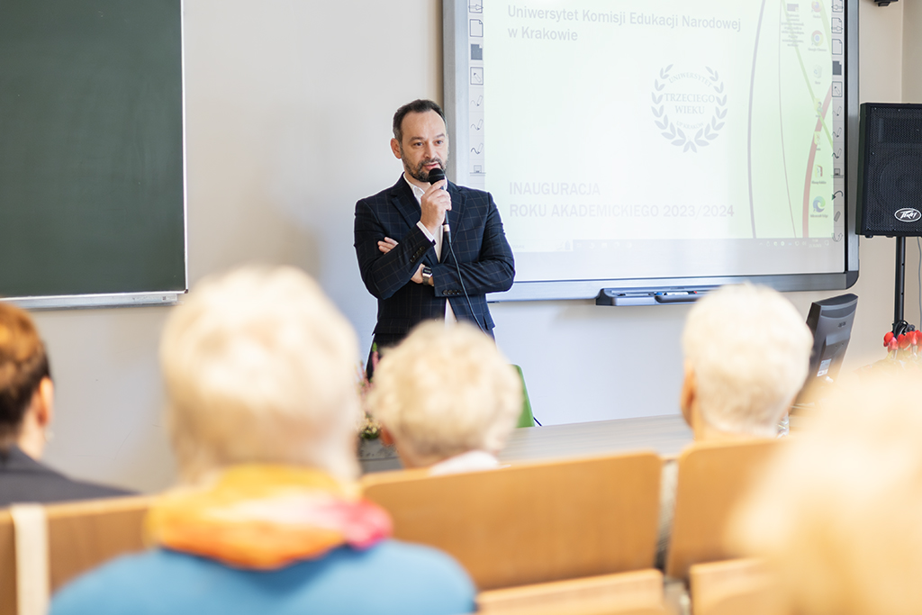 Zastępca Dyrektora Instytutu Zarządzania i Spraw Społecznych dr Krzysztof Chaczko z mikrofonem w dłoni, na pierwszym planie słuchacze UTW