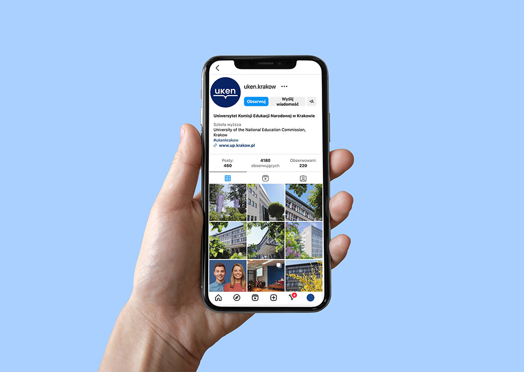 wyciągnięta dłoń z telefonem, na którym widać stronę na Instagramie Uniwersytetu Komisji Edukacji Narodowej w Krakowie