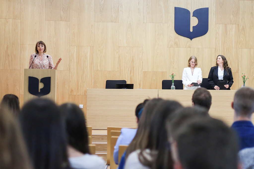 Dyrektor Instytutu Historii i Archiwistyki dr hab. Agnieszka Chłosta-Sikorska, prof. UP otwiera zjazd, obok prowadzące wydarzenie studentki; na pierwszym planie uczestnicy zjazdu