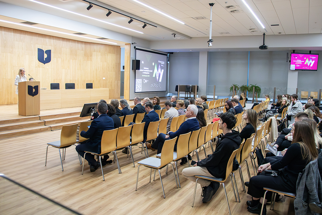 Dr Agata Nodżak przy pulpicie, na pierwszym planie uczestnicy konferencji