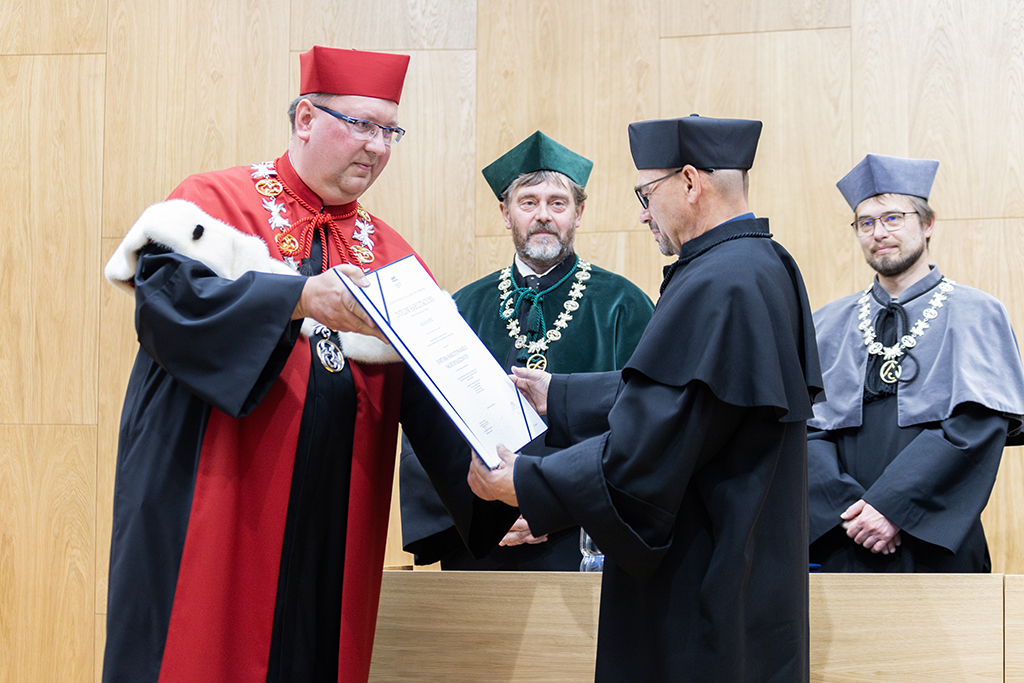 Prorektor ds. Nauki dr hab. Michał Rogoż, prof. UKEN wręcza dyplom dr. hab. Rafałowi Kopciowi