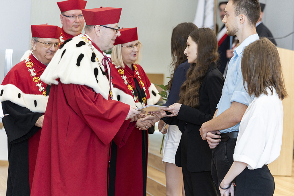 władze rektorskie wręczają listy gratulacyjne wyróżnionym studentom