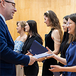 Rektor Uniwersytetu Komisji Edukacji Narodowej w Krakowie prof. dr hab. Piotr Borek wręcza pamiątkowe dyplomy za zaangażowanie w działania promocyjne uczelni