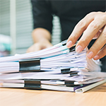 zbliżenie na dłonie osoby przeglądającej dokumenty