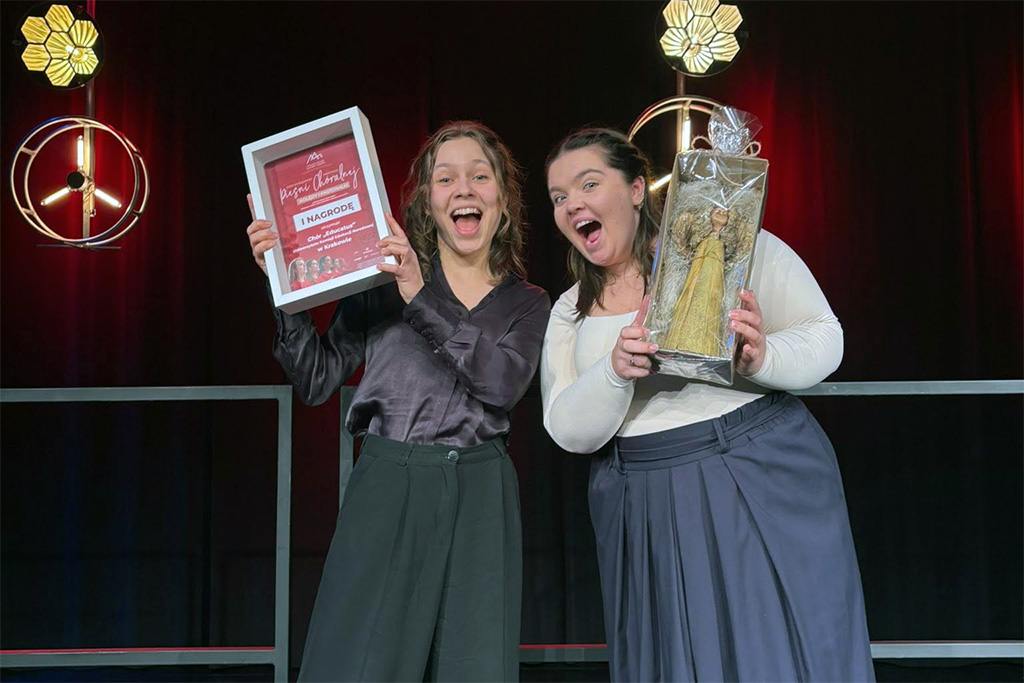 dyrygentka Joanna Kosiba z&nbsp;otrzymanym wyróżnieniem w&nbsp;dłoniach, obok niej jedna z&nbsp;chórzystek