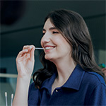 uśmiechnięta brunetka w granatowej bluzce podczas pobierania wymazu